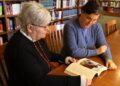 Kathy Hipps, Director of the Thomas J. Garland Library, and Dr. Aja Matthews, Assistant Professor of Sociology, look at the book "Diné: A History of the Navajos" by Peter Iverson.