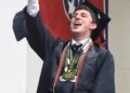 Master’s degree recipient Zackary Nelson celebrates after his name is called during graduation.