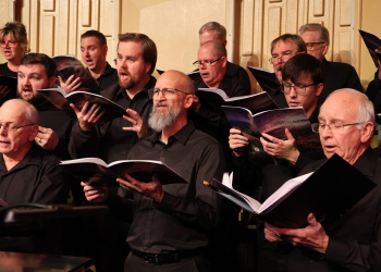 Members of the chorus sing during their final rehearsal for the Christmas concert.