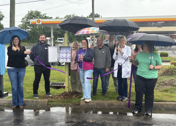 GCADC and Action Recovery Resource Center representatives, Community Pharmacy owner and pharmacist Shelly Lewis and others cut the ribbon in the rain today at the box located in front of the store next to Tusculum Boulevard.