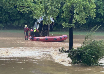 Members of the Caney Branch VFD approach one of dozens of disabled vehicles swept away by the flood waters Thursday.