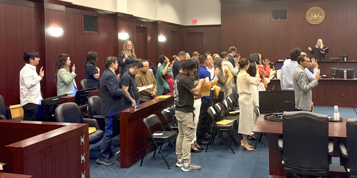 Those becoming citizens take an oath of allegiance to America during a naturalization ceremony held Wednesday at the Federal Courthouse.