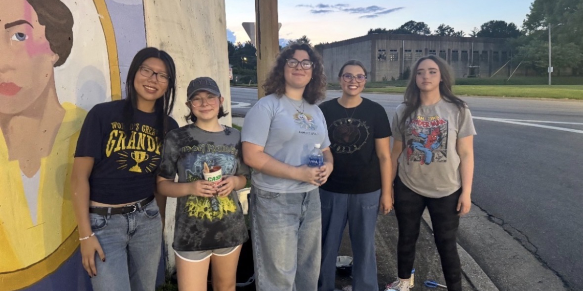 These Greeneville High students, members of the National Art Honor Society, showed up to repair the mural after vandals damaged it the night before