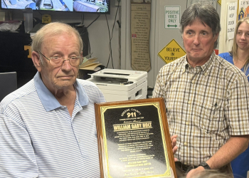 Greene County 911 Director Jerry Bird, right, presents the plaque that will be placed in the 911 Dispatch Center honoring William Gary Holt to Holt, left, during a ceremony Tuesday.