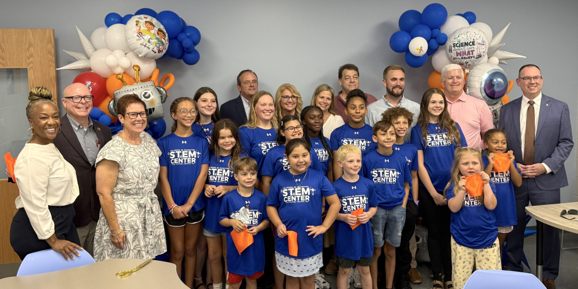 Boys and Girls Club staff, kids, and other public figures pose for a photo after cutting the ribbon on the new STEM Center at the Boys and Girls Club.