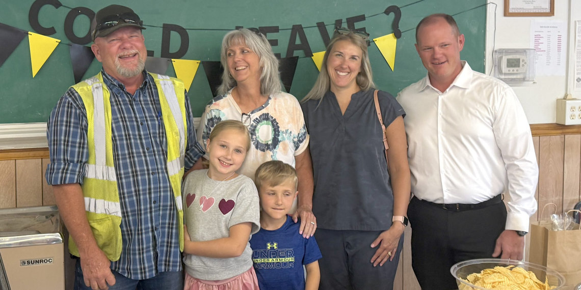 Retiring Greene County Road Superintendent Kevin Swatsell, at left, laughs as he poses for a group photo with his family members during a surprise retirement reception at the Greene County Highway Department on Wednesday afternoon.