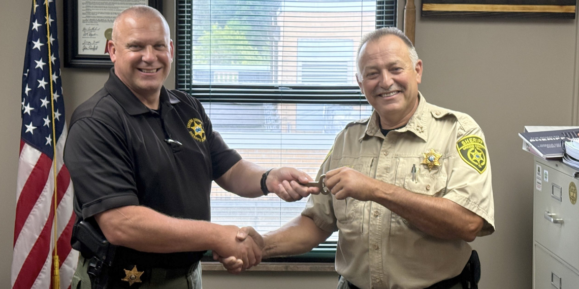 Incoming Greene County Sheriff David Beverly, left, receives the keys to the Greene County Jail from outgoing Sheriff Wesley Holt, right, during a ceremonial exchange on Monday afternoon.
