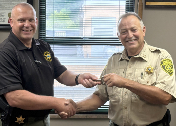 Incoming Greene County Sheriff David Beverly, left, receives the keys to the Greene County Jail from outgoing Sheriff Wesley Holt, right, during a ceremonial exchange on Monday afternoon.