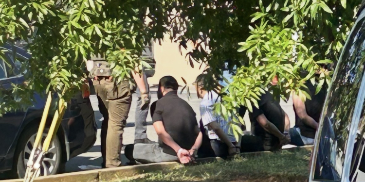 Some of those arrested and in handcuffs Wednesday surrounded by law enforcement (Radio Greeneville News photo)