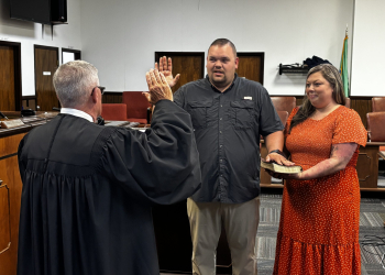 County Commissioner Chase Murry with his hand on the Bible being held by his wife Sarah during the swearing in ceremony Monday.