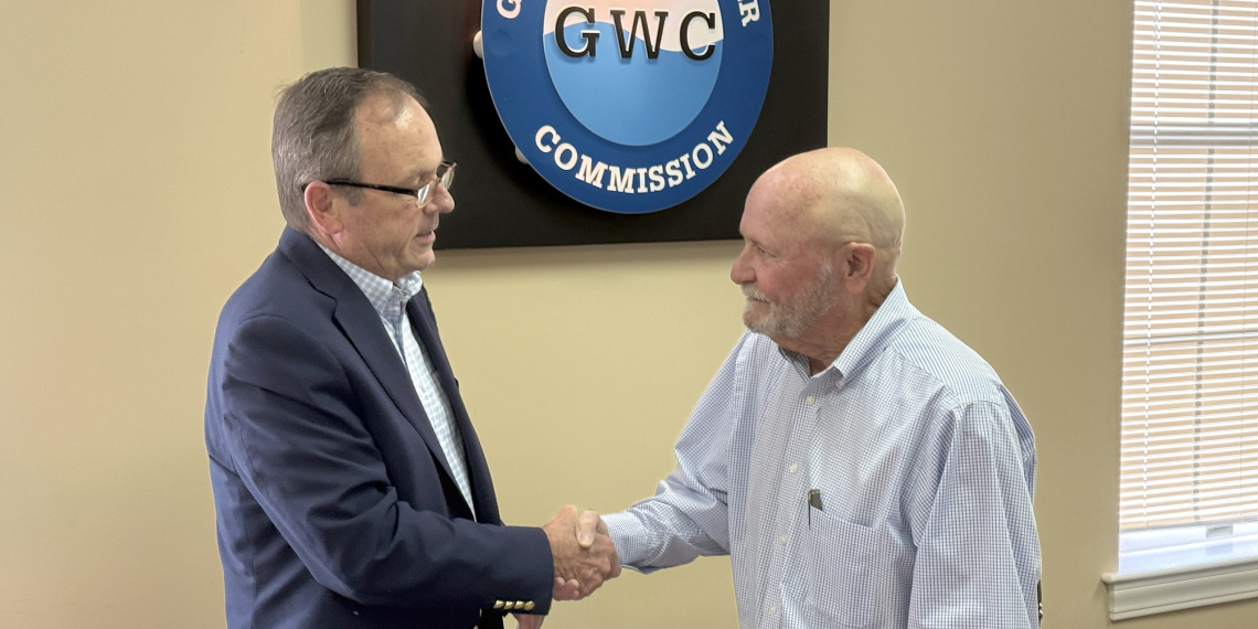 Greeneville Water Commissioner Johnny Honeycutt, right, shakes hands with Greeneville Mayor Cal Doty, left, after being sworn in for a another term on the Water Commission board on Tuesday morning.